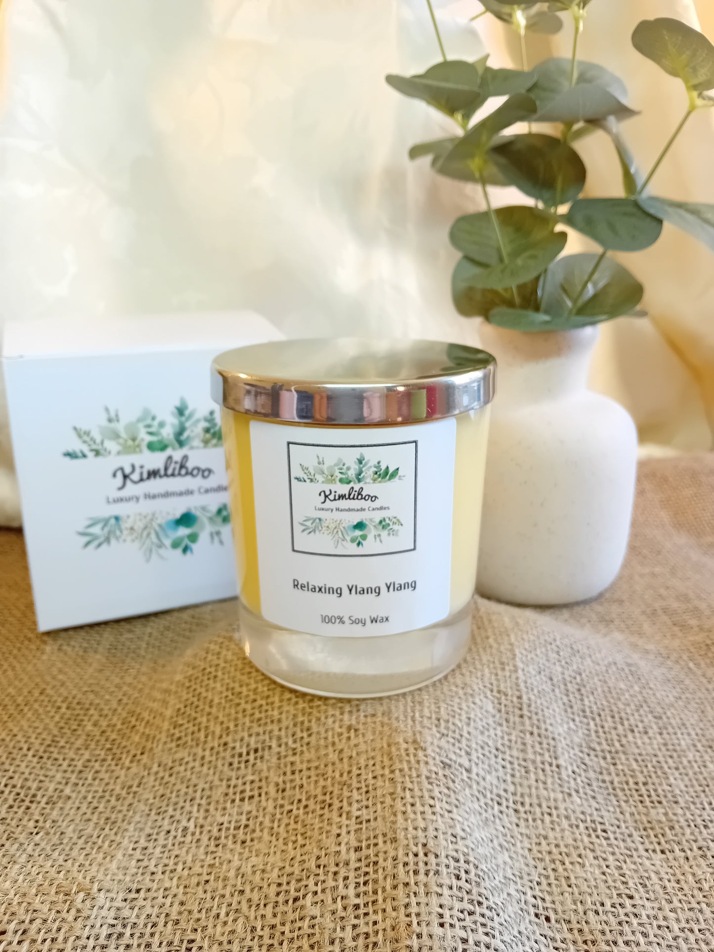 Relaxing Ylang Ylang fragranced yellow candle with silver lid and white presentation box.