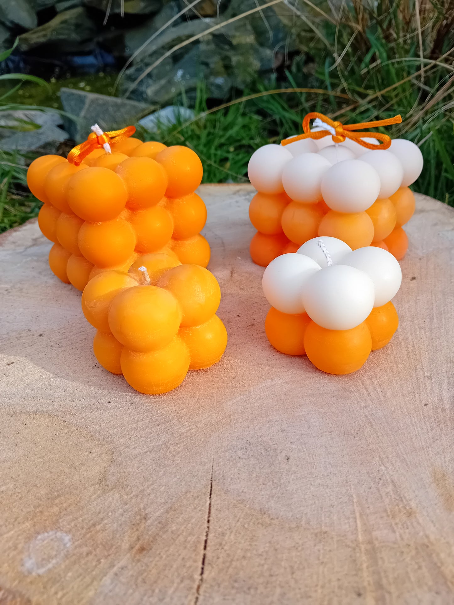 Plain orange and ombre white/orange fragranced Bubble candles - two of them are large, two are mini.