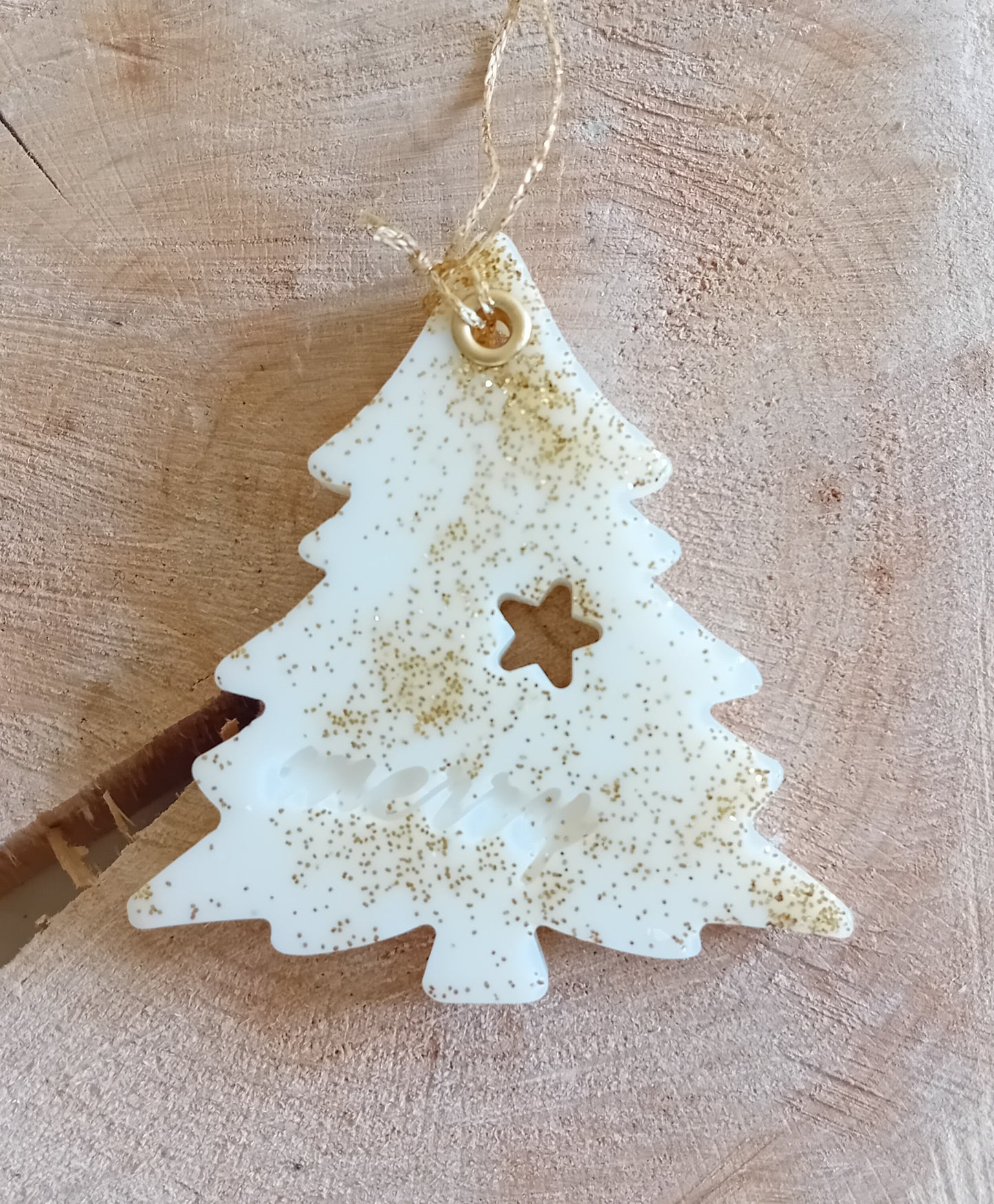 Christmas Tree shaped wax sachet decorated with gold glitter with a wooden log slice background.