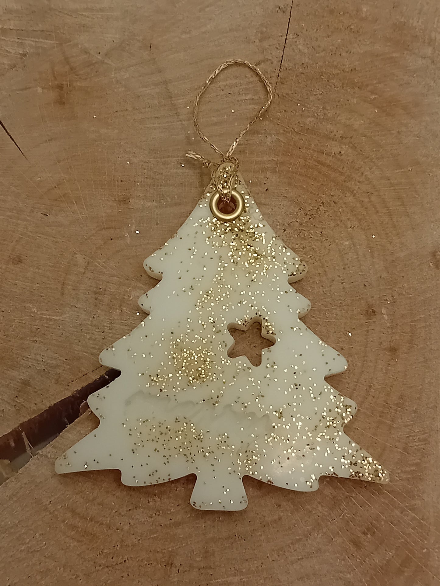 Christmas Tree shaped wax sachet decorated with gold glitter with a wooden log slice background.