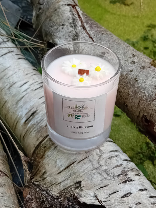 Pink candle with daisy decorations on a tree branch