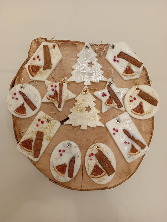 Wooden log slice with variously decorated shaped wax sachets on a log slice background.