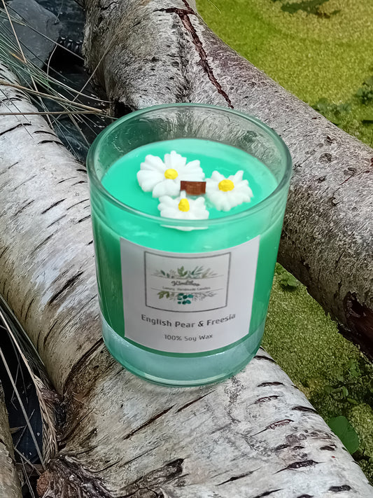 Green candle with daisy decorations on a tree branch