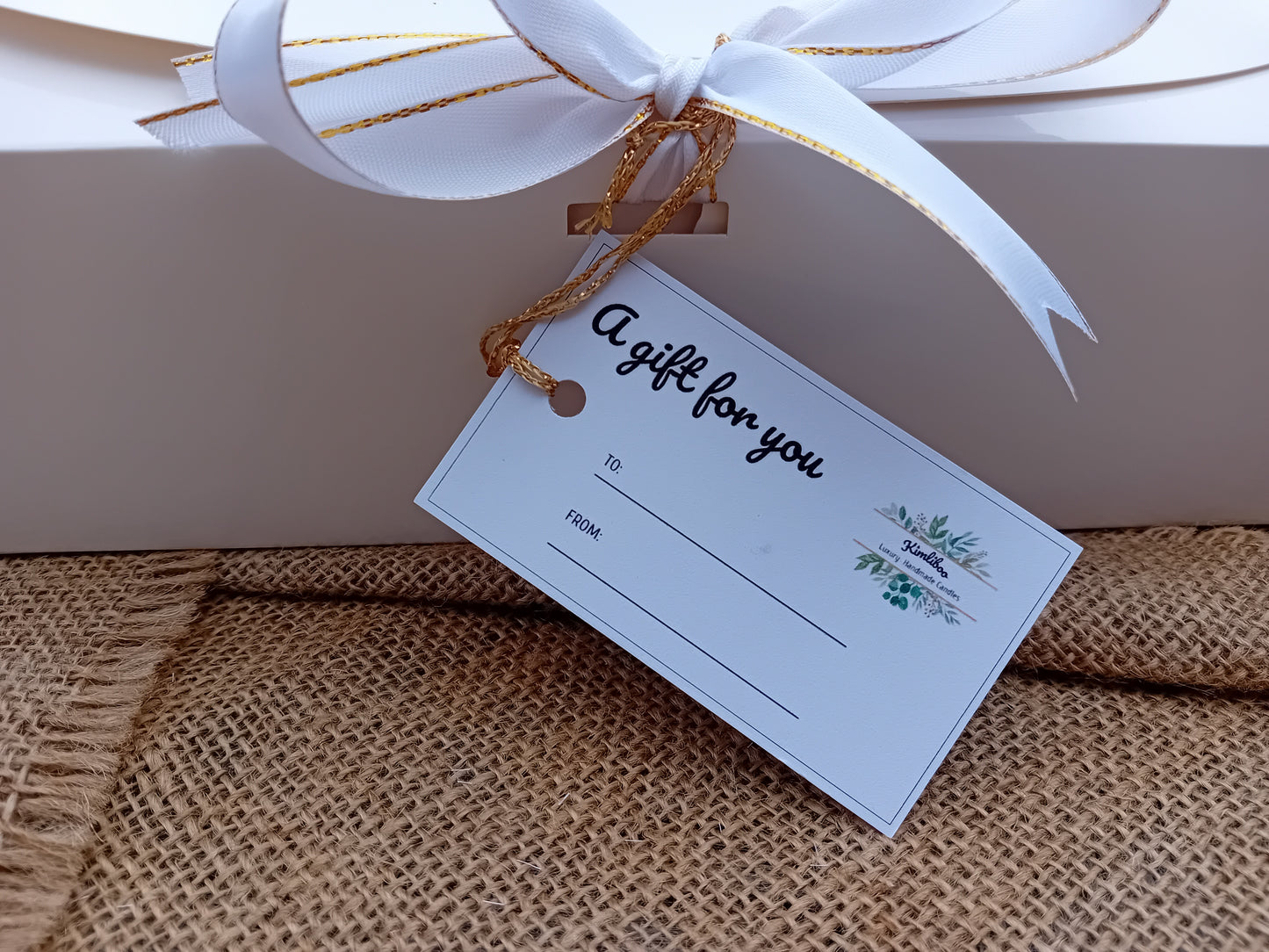 Gift tag attached to gift box with a gold thread