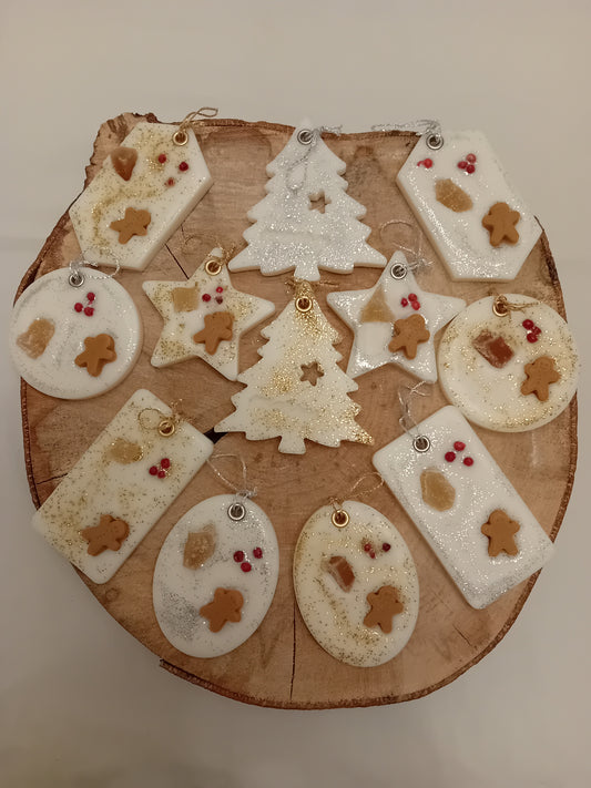 Wooden log slice with variously decorated shaped wax sachets on a log slice background.