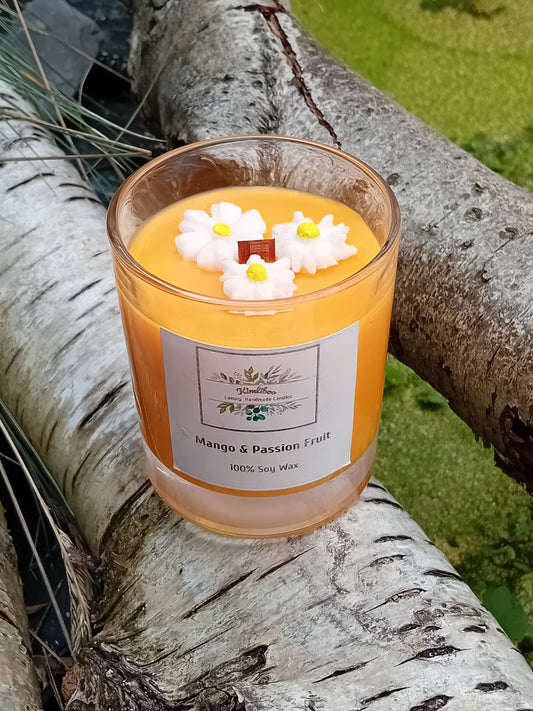 Orange candle with daisy decorations on a tree branch