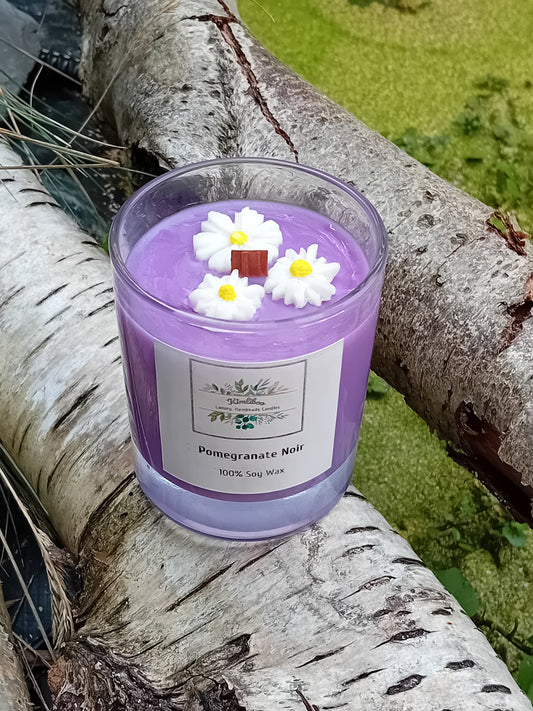 Purple candle with daisy decorations on a tree branch