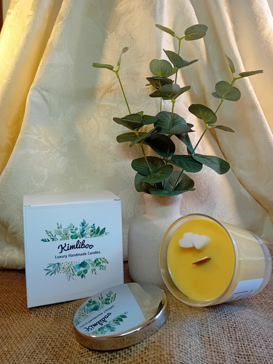 Relaxing Ylang Ylang fragranced yellow candle with wooden wick and two white heart-shaped wax decorations. 