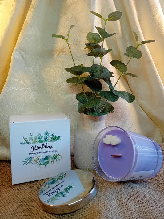 Lavender fragranced lilac candle with wooden wick and two white heart-shaped wax decorations.