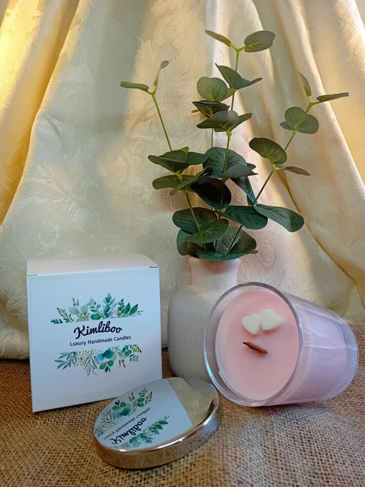 Cherry Blossom fragranced pink wooden wick candle with two white heart-shaped wax heart decorations.