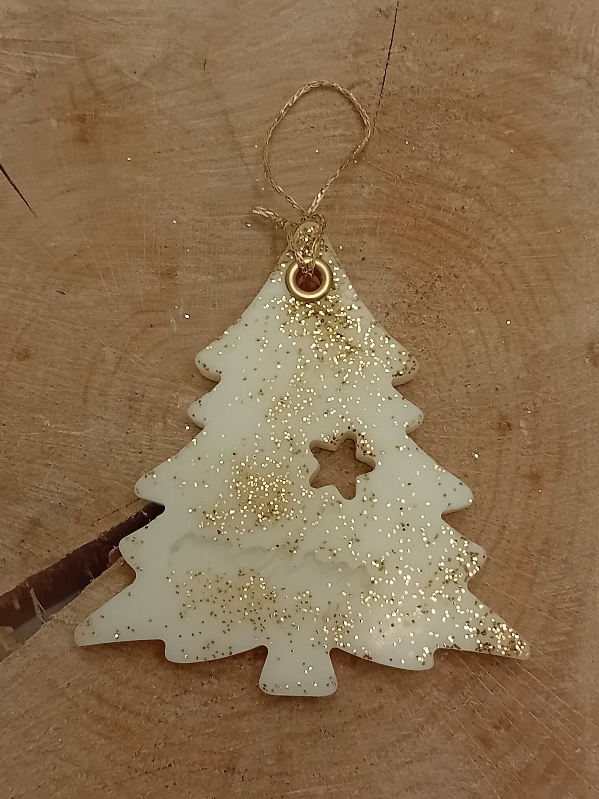 Christmas Tree shaped wax sachet decorated with gold glitter with a wooden log slice background.
