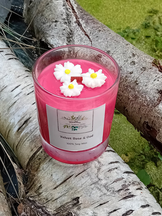 Deep red candle with daisy decorations on a tree branch