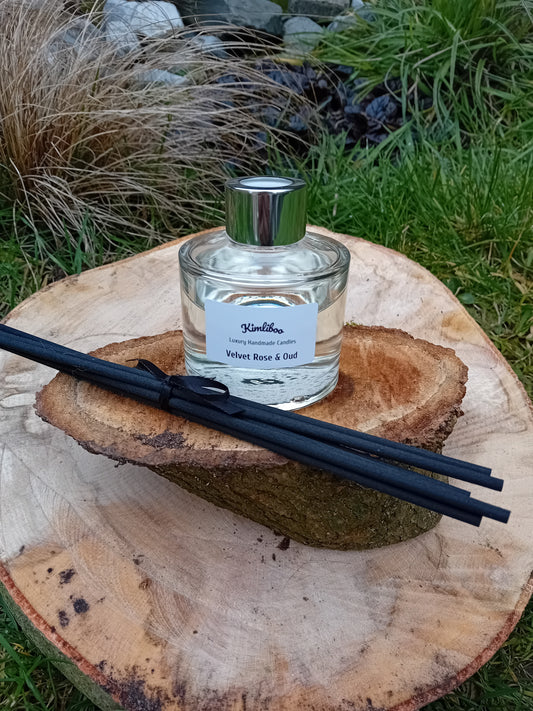 Velvet Rose & Oud  fragranced reed diffuser with a 100ml clear glass jar and a bundle of black fibre reeds. 
