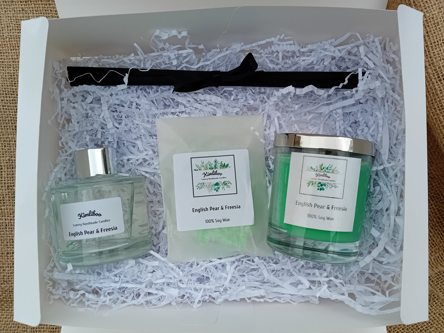 Reed diffuser, reeds, wax melts and candle inside a white gift box