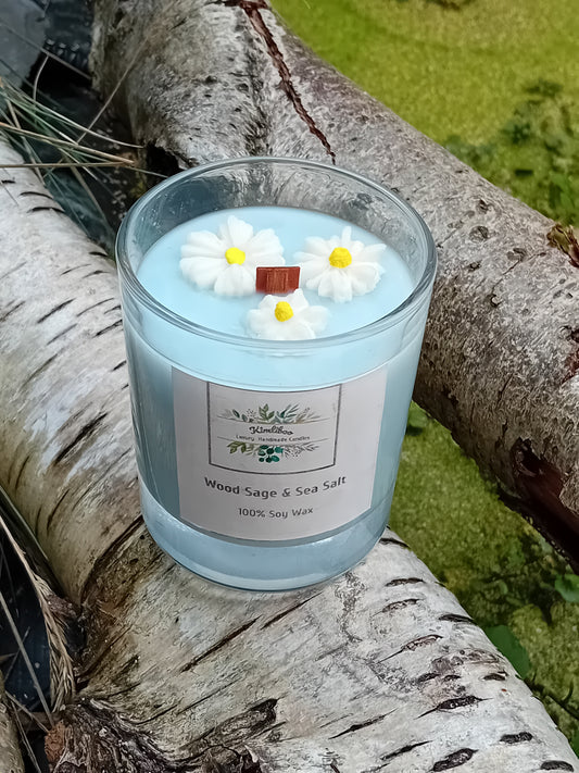 Light blue candle with daisy decorations on a tree branch